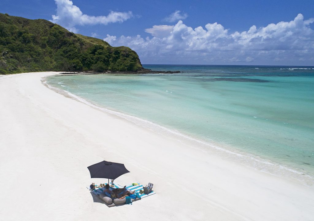 A Couple Relaxing on Pristine Beach at Yasawa Island Resort